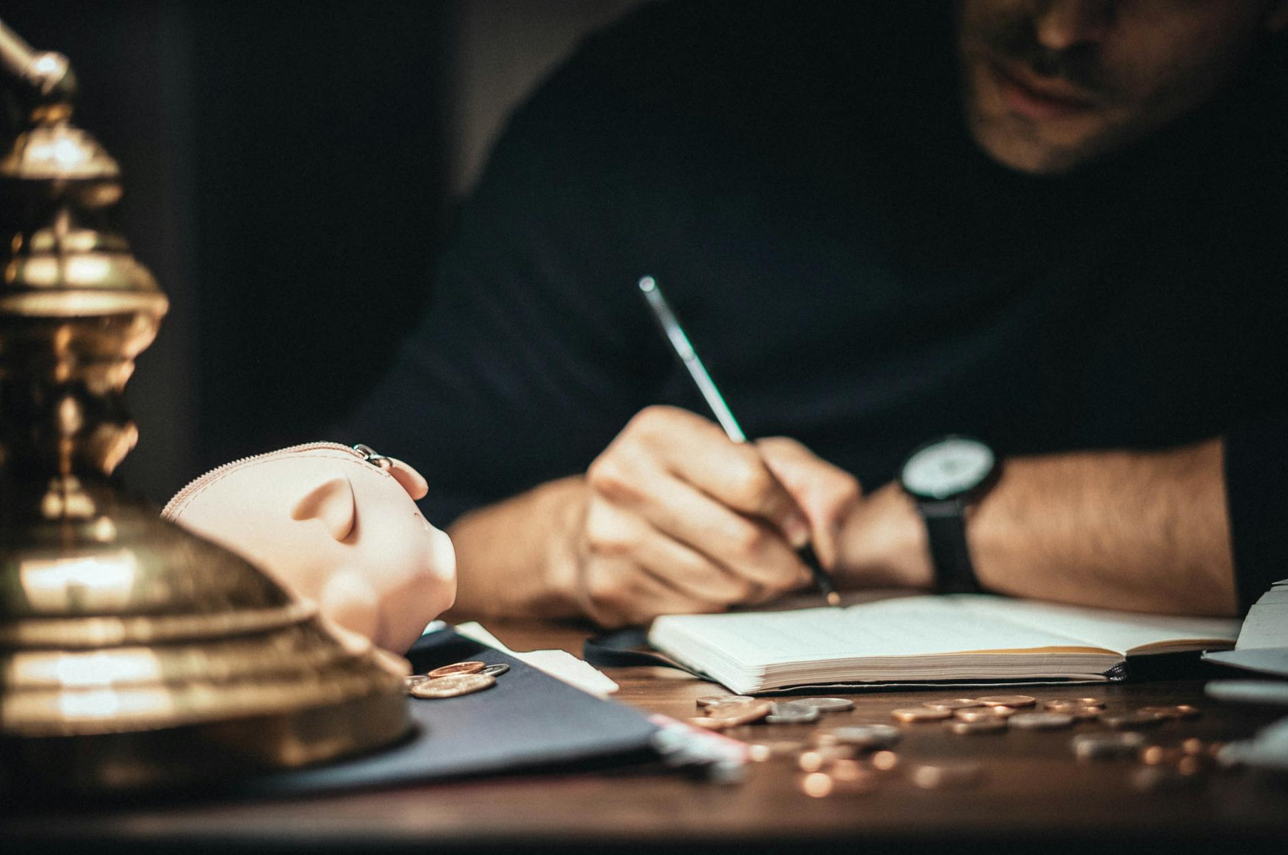 man writing down on a stationery