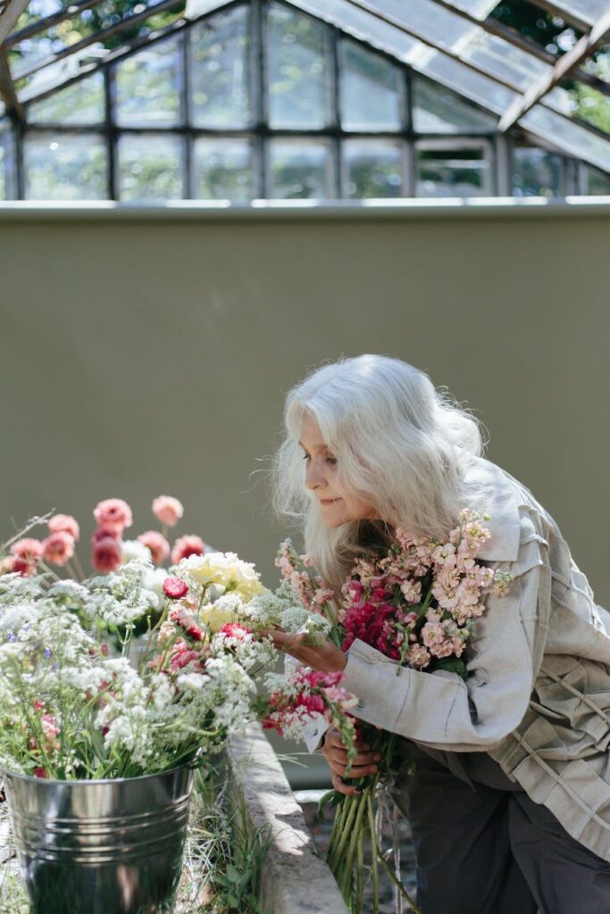 an elderly woman looking at flowers