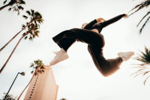 woman in sportswear jumping in air in tropical landscape