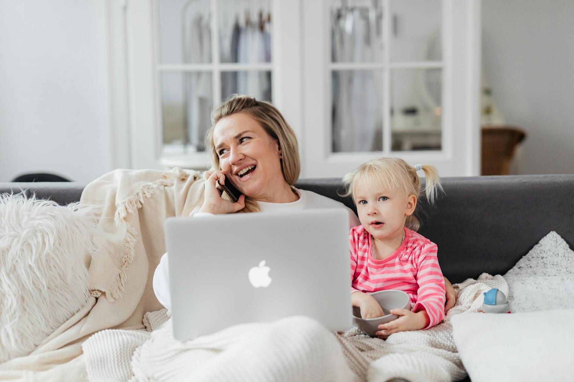 woman talking on phone on sofa with girl