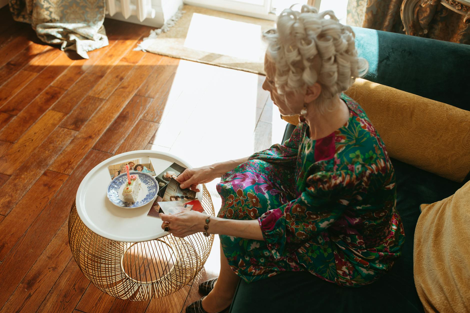 high angle shot of elderly woman looking at her vintage photos